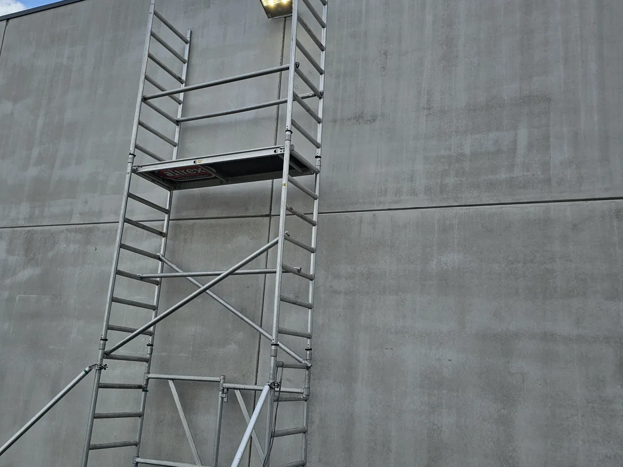 Pose d'une applique extérieure sur échafaudage en façade