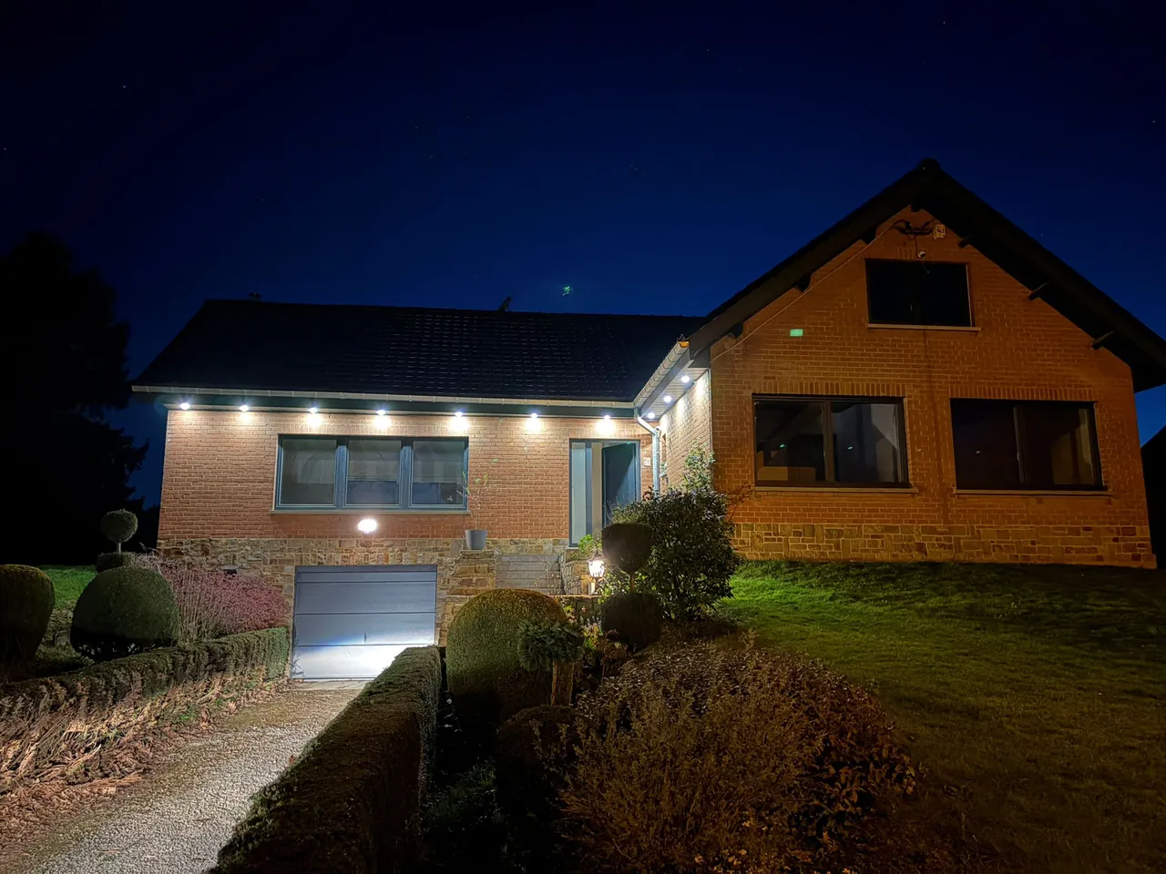 Éclairage extérieur de façade d'une maison à la tombée de la nuit